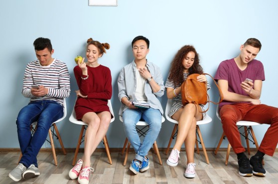 Grupo de jóvenes esperando para hacer una entrevista de trabajo.