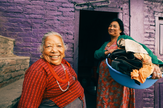 Dos mujeres de ascendencia asiática en un entorno de vivienda empobrecida.